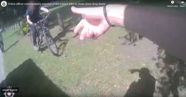 Handout still from a police body-cam video issued by Northamptonshire Police of the moment Pc Lewis Marks commandeers a bicycle from a member of the public to chase down a drug dealer 