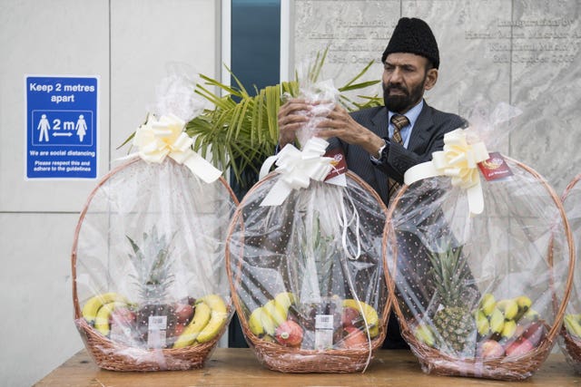 A volunteer prepares to give out fruit baskets to worshippers at the Baitul Futuh Mosque in Mordon, south London, ahead of Eid al-Fitr last year