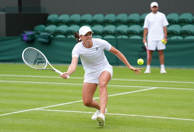 Iga Swiatek crouches to play a forehand during a practice session at Wimbledon