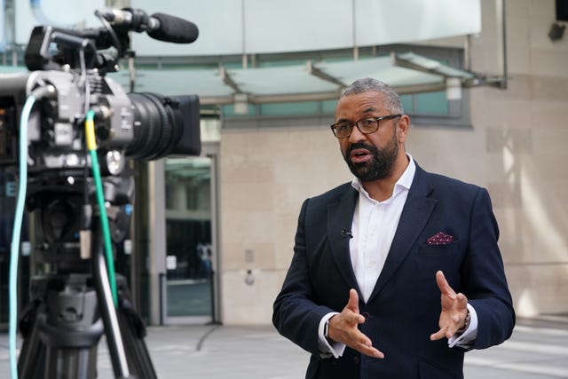 James Cleverly gesturing with his hands while speaking in front of a television camera