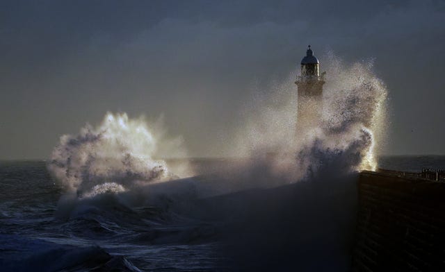 Waves batter a pier, jumping high into the air