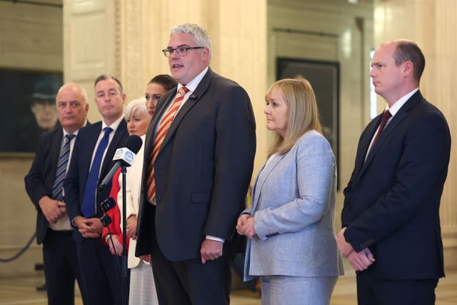 DUP leader Gavin Robinson, forward, speaking to members of the media in the Great Hall in Stormont, Belfast