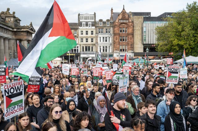 People take part during a silent funeral procession through Edinburgh city centre on Saturday