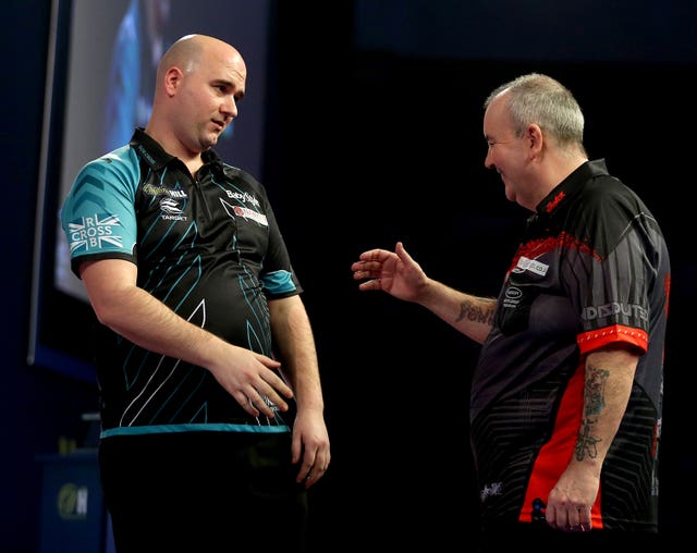 Cross is congratulated by Phil Taylor, right, after his victory in the 2018 PDC World Championship final