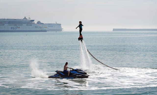 A lady enjoys flyboarding during the warm weather on the beach in Dover, Kent, on July 19 2024 