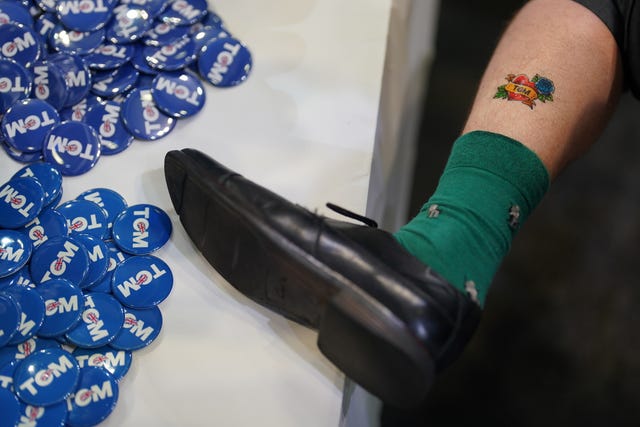 A man shows off his temporary Tugend-tat - a heart-shaped temporary tattoo with the name 'Tom' in the centre for Tom Tugendhat's Conservative Party leadership campaign - next to 'Tom' badges