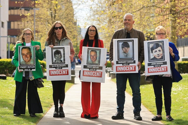 Relatives of those killed during the Springhill Westrock killings holding placards outside Belfast Coroner’s Court