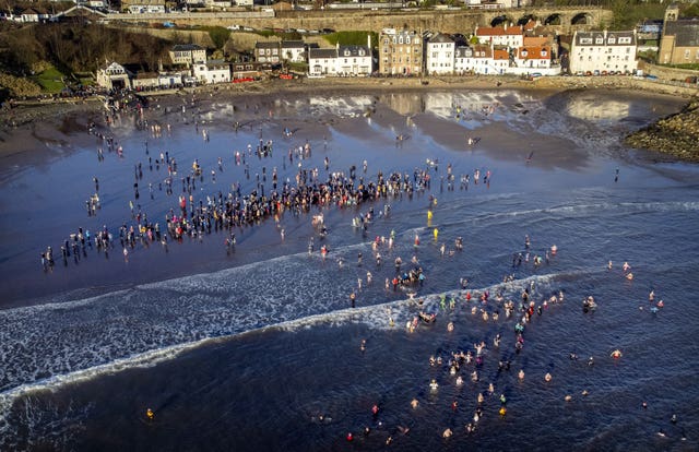 People take part in a loony dook dip in the Firth of Forth at Kinghorn, Fife, on the first day of 2024