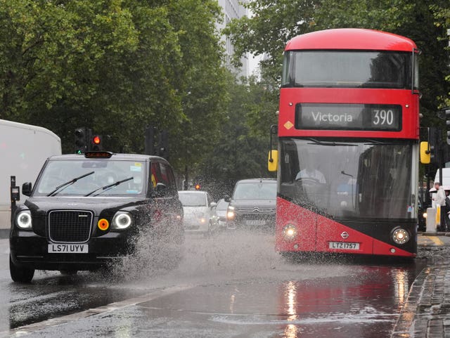 The 390 bus to Victoria approaches a big puddle on the side of Euston Road in London