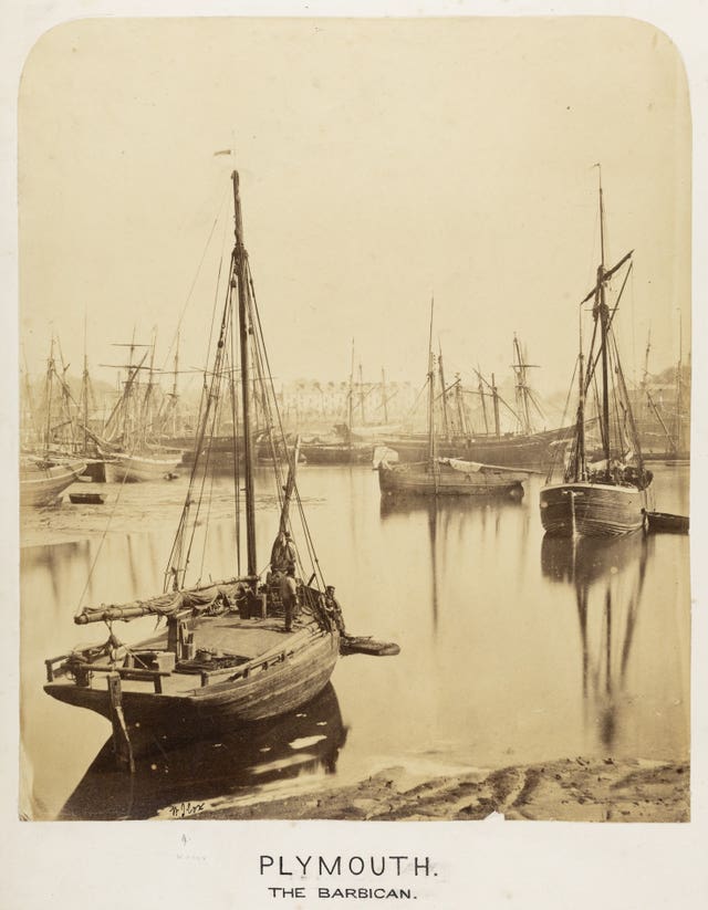 A sepia black and white image of boats on still water, the words 'Plymouth' and 'The Barbican' are underneath