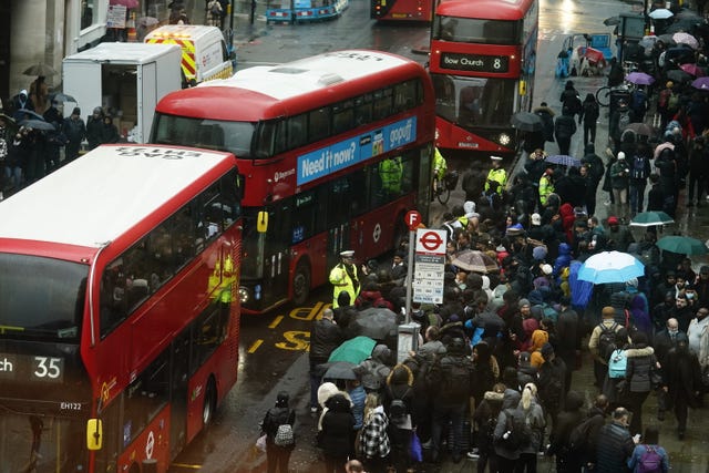 People wait to get on buses at Liverpool Street station in central London on Tuesday