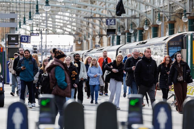 Passengers walk along a platform at Glasgow Central