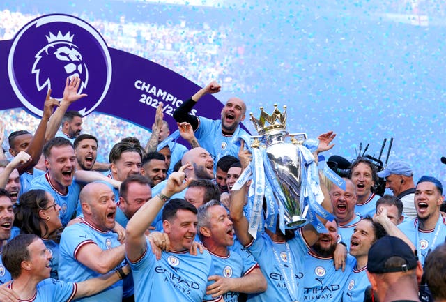 Manchester City players celebrate with the Premier League trophy