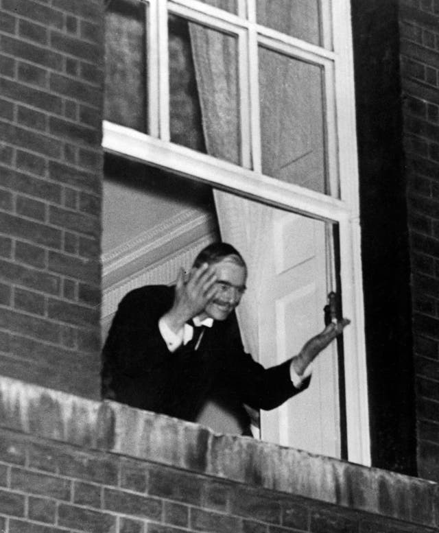 Neville Chamberlain waves to crowds from the window of 10 Downing Street in 1938 (PA Archive)