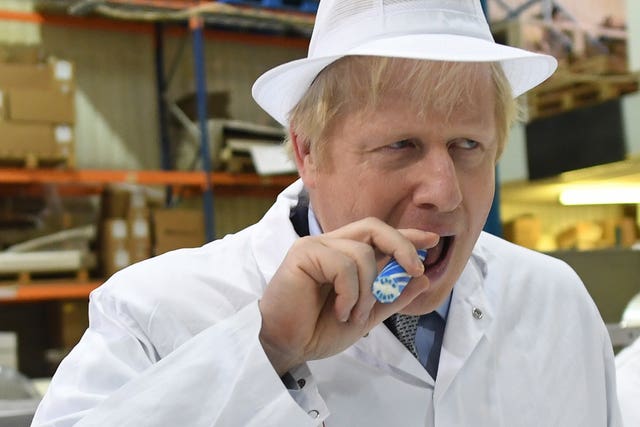 Prime Minister Boris Johnson eats some rock during a visit to Coronation Candy in Blackpool during the general election campaign (Stefan Rousseau/PA)