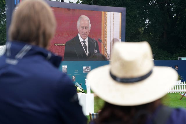 Spectators watch the Accession Council, where King Charles III is formally proclaimed monarch, on the big screen at Wentworth Golf Club 