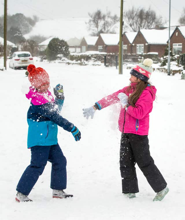 Isla Wallace (left) and Millie Johnson (right) have a snowball fight in Yeadon, Yorkshire (Danny Lawson/PA)
