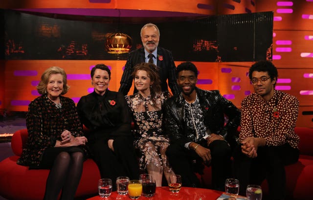 Host Graham Norton with (seated left to right) Lady Anne Glenconner, Olivia Colman, Helena Bonham Carter, Chadwick Boseman and Richard Ayoade 