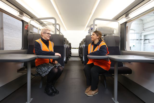 Two train workers sitting in a new HS2 carriage 