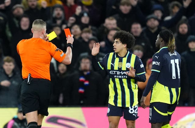 Referee Chris Graham shows a red card to Manchester City’s Rico Lewis 