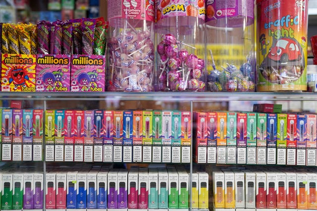 Brightly coloured vapes on sale directly below sweets