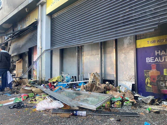 Parts of the building lie in front of Sham Supermarket on Donegall Road in Belfast after it was attacked during disorder in the area 