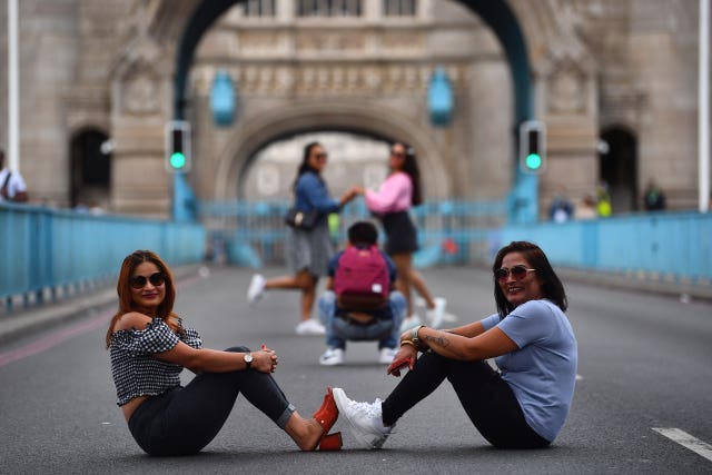 Tourists pose for pictures on Tower Bridge