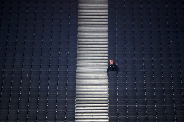 Job done, the ball boy sits back in his vantage point from the Stadium MK stands