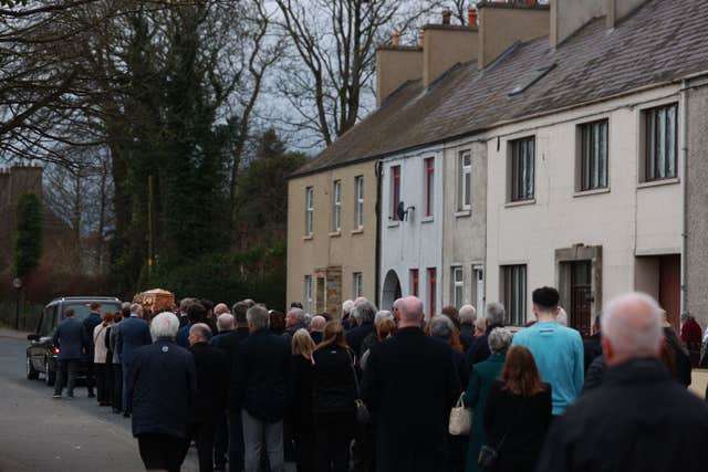 Mary Kielty's coffin is carried past her family home on Main Street, Dundrum