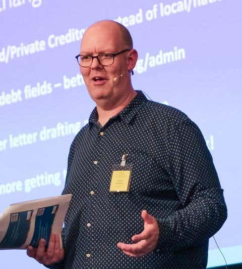 Chris Marriott on a stage wearing a microphone