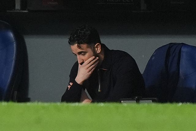 Manchester United manager Ruben Amorim holds his hand to his mouth in the dugout