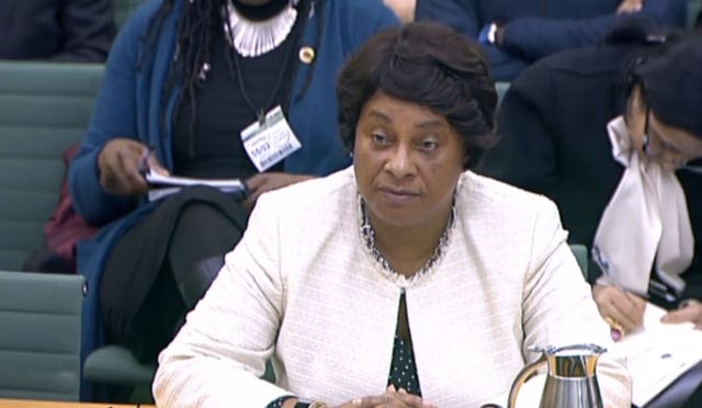 Baroness Doreen Lawrence sitting at a desk wearing a white suit jacket,
