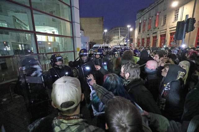 Police hold back people outside Bridewell police station in Bristol