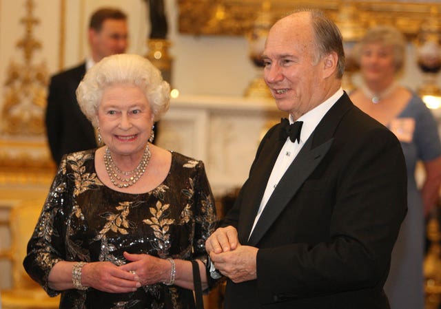 Queen Elizabeth II and The Aga Khan share a smile at a dinner at Buckingham Palace 