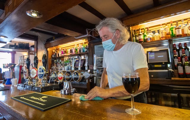 A pub owner wearing a mask 