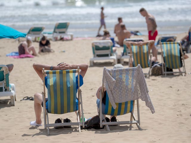 People enjoy the sunshine on the beach in Bournemouth, Dorset (