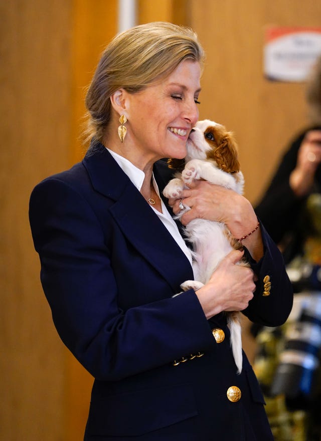 Sophie cuddle puppy Lord Louis of Spudringham during a visit to Dogs for Autism 