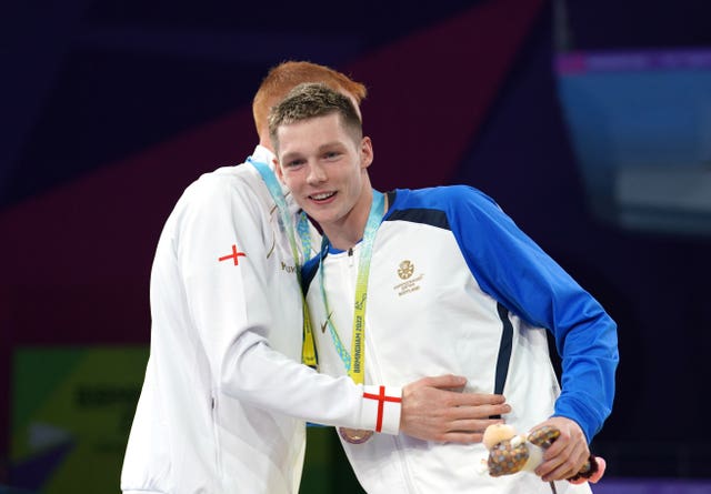 Dean and Scott hug on the podium after receiving their medals 