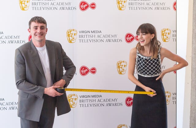 Paul Mescal and Daisy Edgar-Jones measure out one metre of safe social distance as they pose for photographers at the Virgin Media Bafta TV awards at the TV Centre, Wood Lane, London