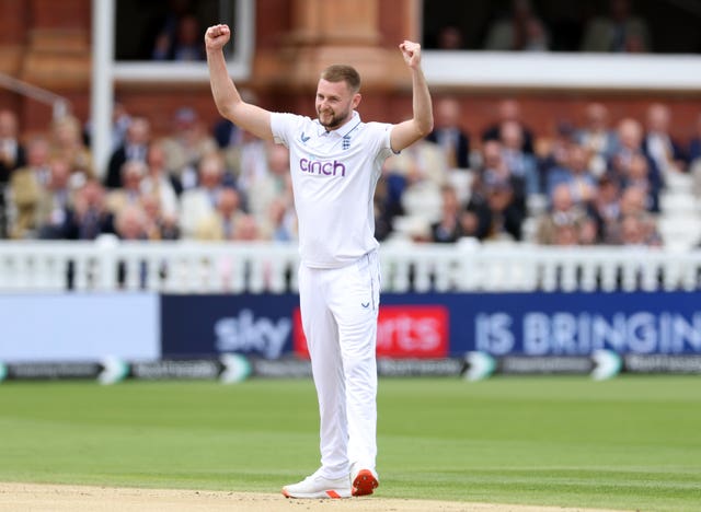 Gus Atkinson celebrates with arms aloft after taking a wicket at Lord's