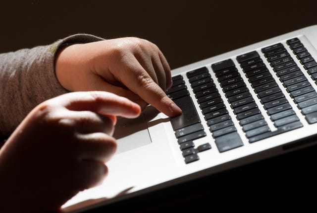 Child typing on computer