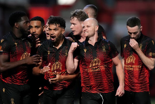 Tamworth players celebrate their first goal of the game against Huddersfield