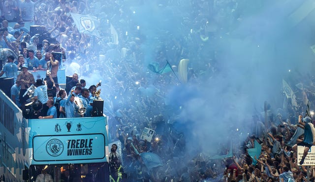 A general view of the Manchester City team buses passing by fans during the treble parade