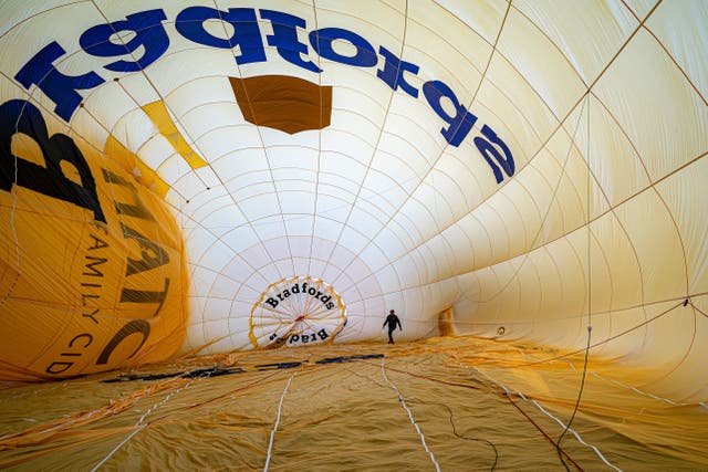 A hot air balloon pilot checks the rigging inside a balloon canopy at the 46th Bristol International Balloon Fiesta