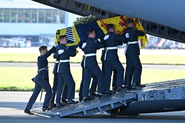 A bearer party from Queen’s Colour Squadron of the RAF carry the Queen's coffin aboard a C17 aircraft