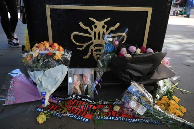 Flowers and a picture of Chloe Rutherford and Liam Curry, who were killed in the Manchester Arena attack, left against a Tree of Hope in Manchester (Peter Byrne/PA)