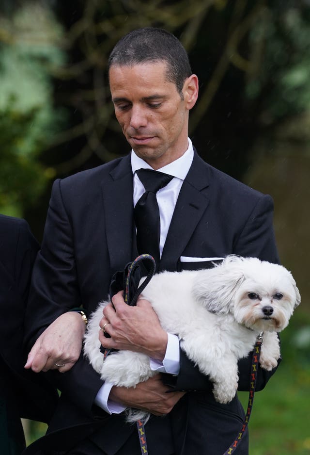 Andre Portasio carrying one of the dogs he shared with Paul O'Grady at the TV stalwart's funeral