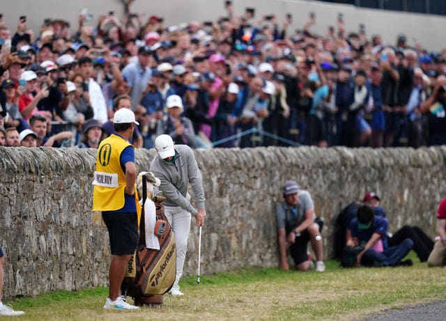 Rory McIlroy plays from against the wall at the 17th hole