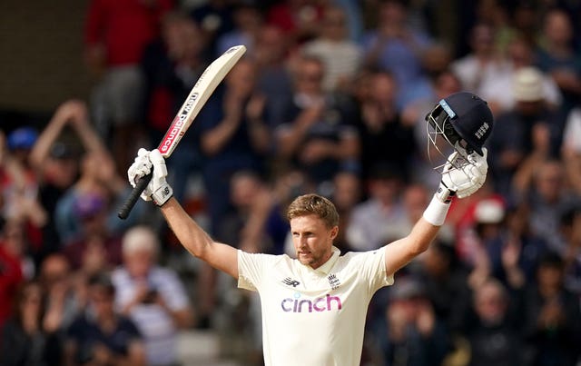 England's Joe Root raises his bat and helmet to celebrate his century against India