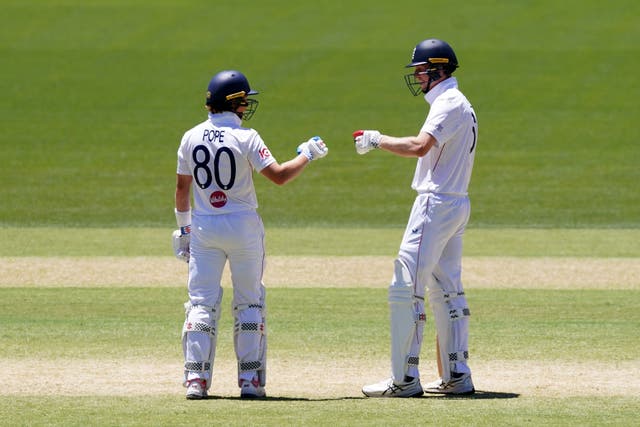 England's Ollie Pope, left, and Zak Crawley fist-bump on day four of the third Ashes Test in Adelaide